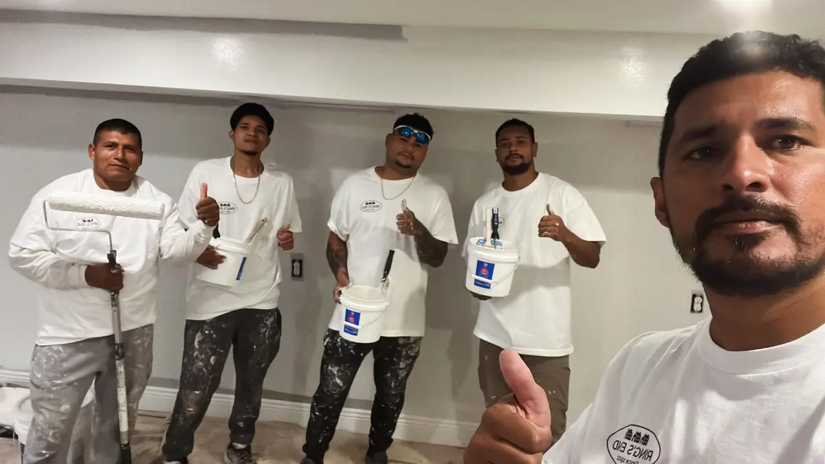 Paulo Nascimento with four members of the Paulo Painting crew in uniform
